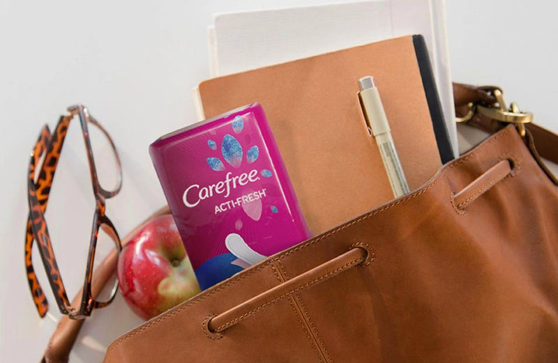 Carefree Acti-Fresh panty liners peeking out of a brown leather purse. 